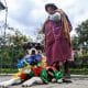Una mujer sostiene a su perro disfrazado de 'Pepino' durante un desfile de mascotas en La Paz (Bolivia). EFE/ Gabriel Márquez