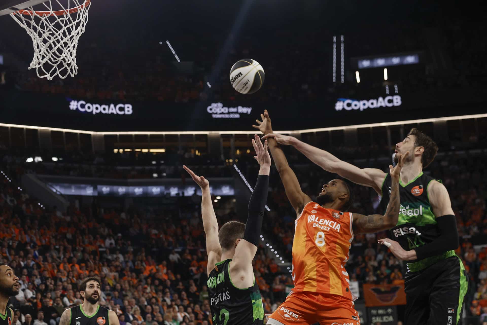 El base del Valencia Jean Montero (c) entra a canasta ante el pívot del Joventut Ante Tomić (d) durante el partido de cuartos de final de la Copa del Rey de baloncesto entre Valencia Basket y el Asisa Joventut Badalona, este jueves en Valencia. EFE/ Kai Försterling