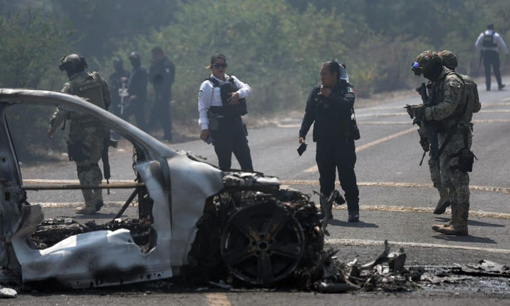 Integrantes de la policía de Morelia y del ejército trabajan en la zona donde fue incendiado un vehículo por presuntos integrantes del crimen organizado este domingo,  tras el abatimiento de Nemesio Oseguera Cervantes, alias El Mencho, líder del Cártel Jalisco Nueva Generación (CJNG), en Morelia (México). EFE/ Iván Villanueva