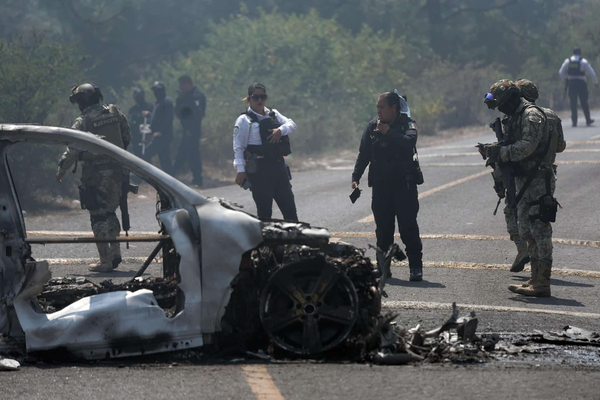Integrantes de la policía de Morelia y del ejército trabajan en la zona donde fue incendiado un vehículo por presuntos integrantes del crimen organizado este domingo,  tras el abatimiento de Nemesio Oseguera Cervantes, alias El Mencho, líder del Cártel Jalisco Nueva Generación (CJNG), en Morelia (México). EFE/ Iván Villanueva