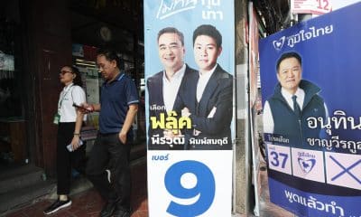 Bangkok (Tailandia), 04/02/2026.- Personas caminan junto a carteles de la campaña electoral del líder del Partido Demócrata y ex primer ministro Abhisit Vejjajiva (izq.) y del primer ministro tailandés y líder del Partido Bhumjaithai, Anutin Charnvirakul (der.), en Bangkok, Tailandia, el 4 de febrero de 2026. EFE/EPA/RUNGROJ YONGRIT
