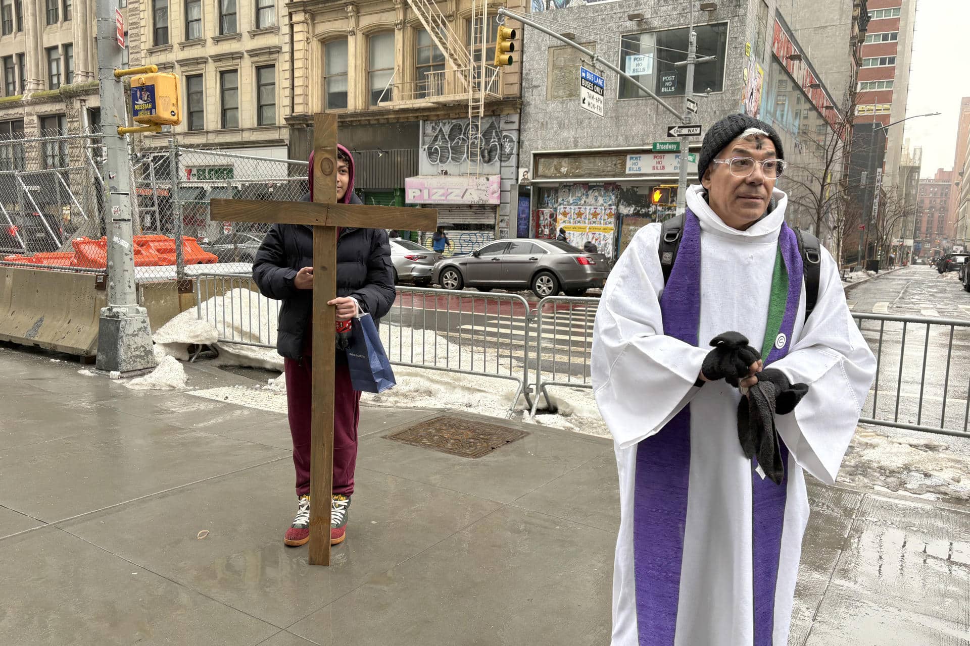Un sacerdote espera a personas para realizarles la imposición de la ceniza este miércoles, frente a la sede del Servicio de Inmigración y Control de Aduanas (ICE) en Nueva York (Estados Unidos). EFE/ Ruth Hernández