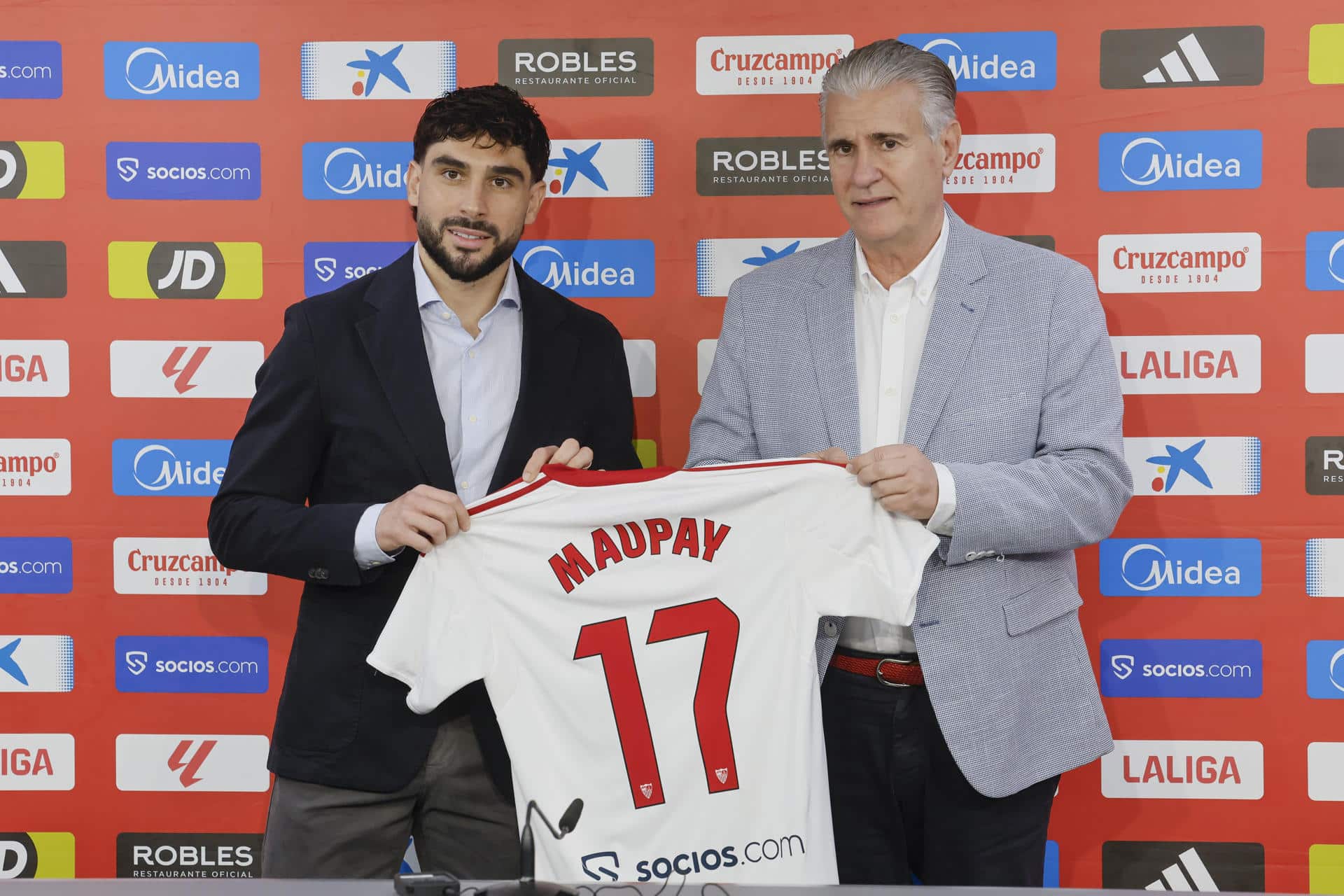 El director de Fútbol Profesional del Sevilla FC, Antonio Cordón (d) en la presentación del delantero francés Neal Maupay (i) en Sevilla. Maupay llega al Sevilla cedido por el Olympique de Marsella. EFE/José Manuel Vidal