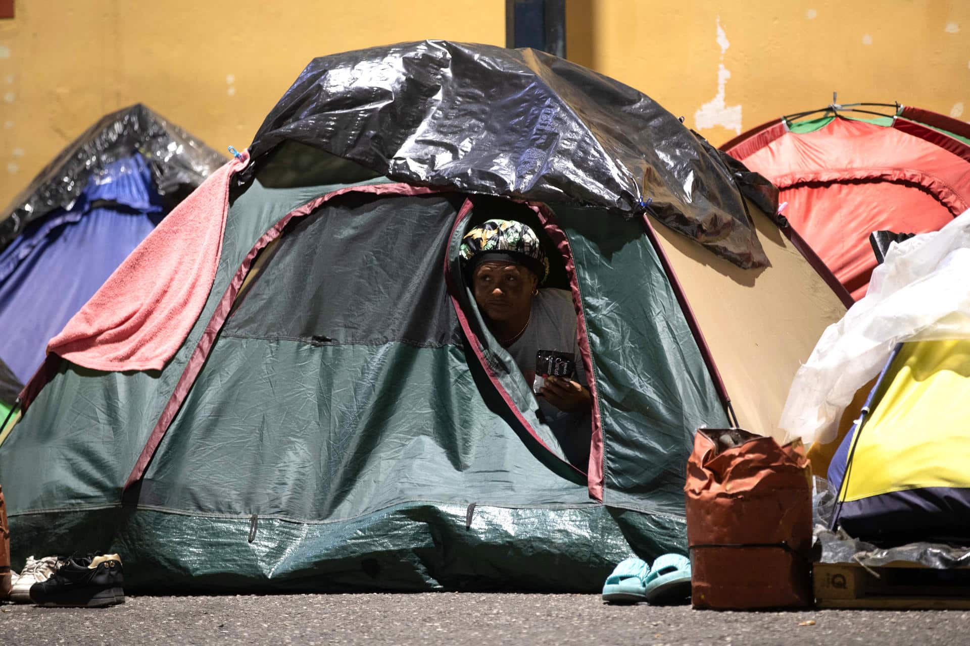 Fotografía del 22 de febrero de 2026 de una persona a la espera de la excarcelación de su familiar dentro de una carpa, frente al comando de la Policía Nacional Bolivariana (PNB) conocido como Zona 7, en Caracas (Venezuela). EFE/ Ronald Pena R