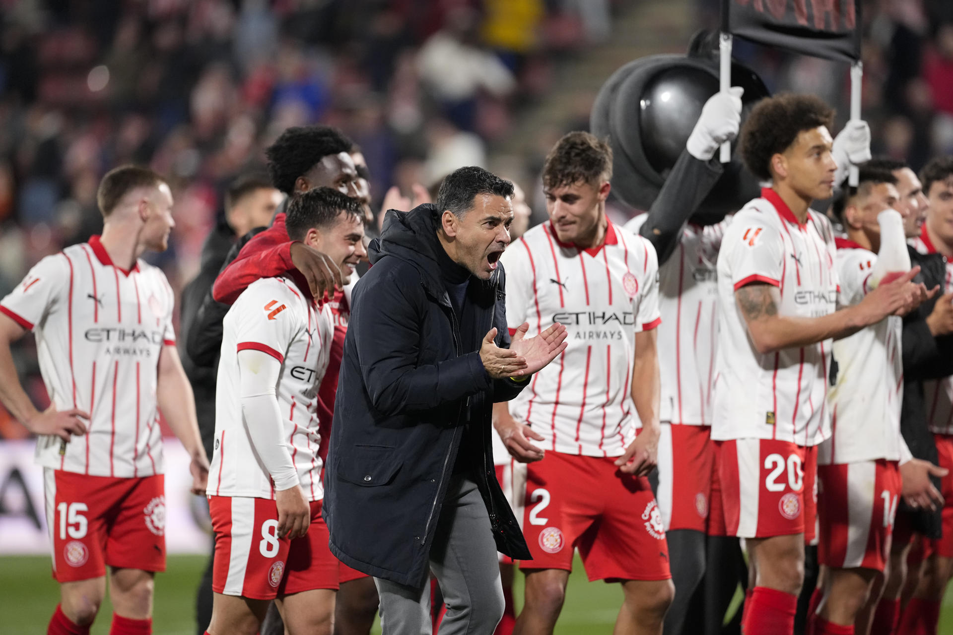 El entrenador y los jugadores del Girona celebran la victoria al finalizar el partido de la jornada 24 de LaLiga de fútbol contra el Barcelona disputaron este lunes en el estadio de Moltilivi. EFE/David Borrat