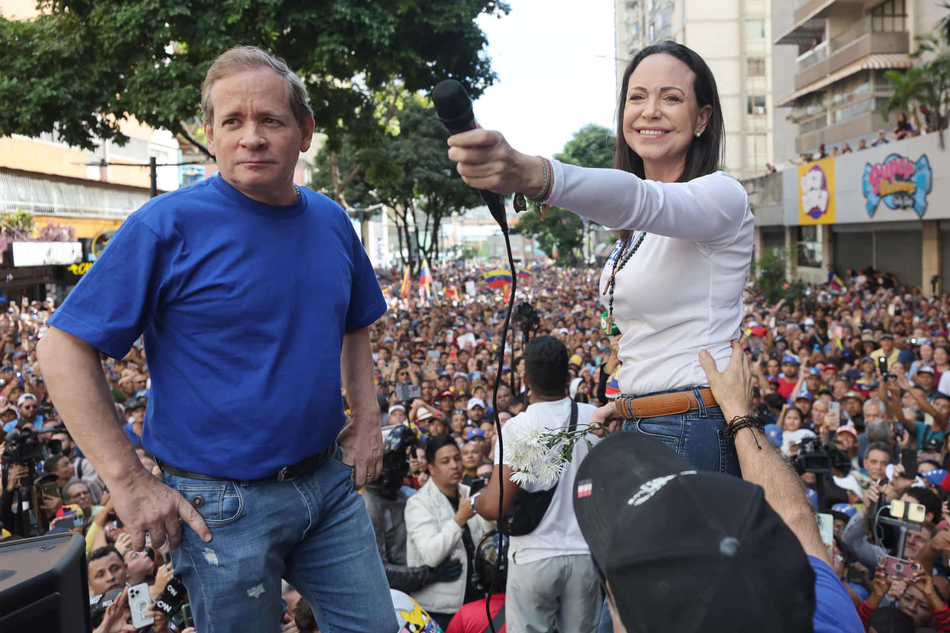 Fotografía de archivo fechada el 09 de enero de 2025 del exdiputado venezolano Juan Pablo Guanipa (i) junto a la líder antichavista María Corina Machado saludando a sus seguidores en una manifestación en Caracas (Venezuela). EFE/ Miguel Gutiérrez ARCHIVO