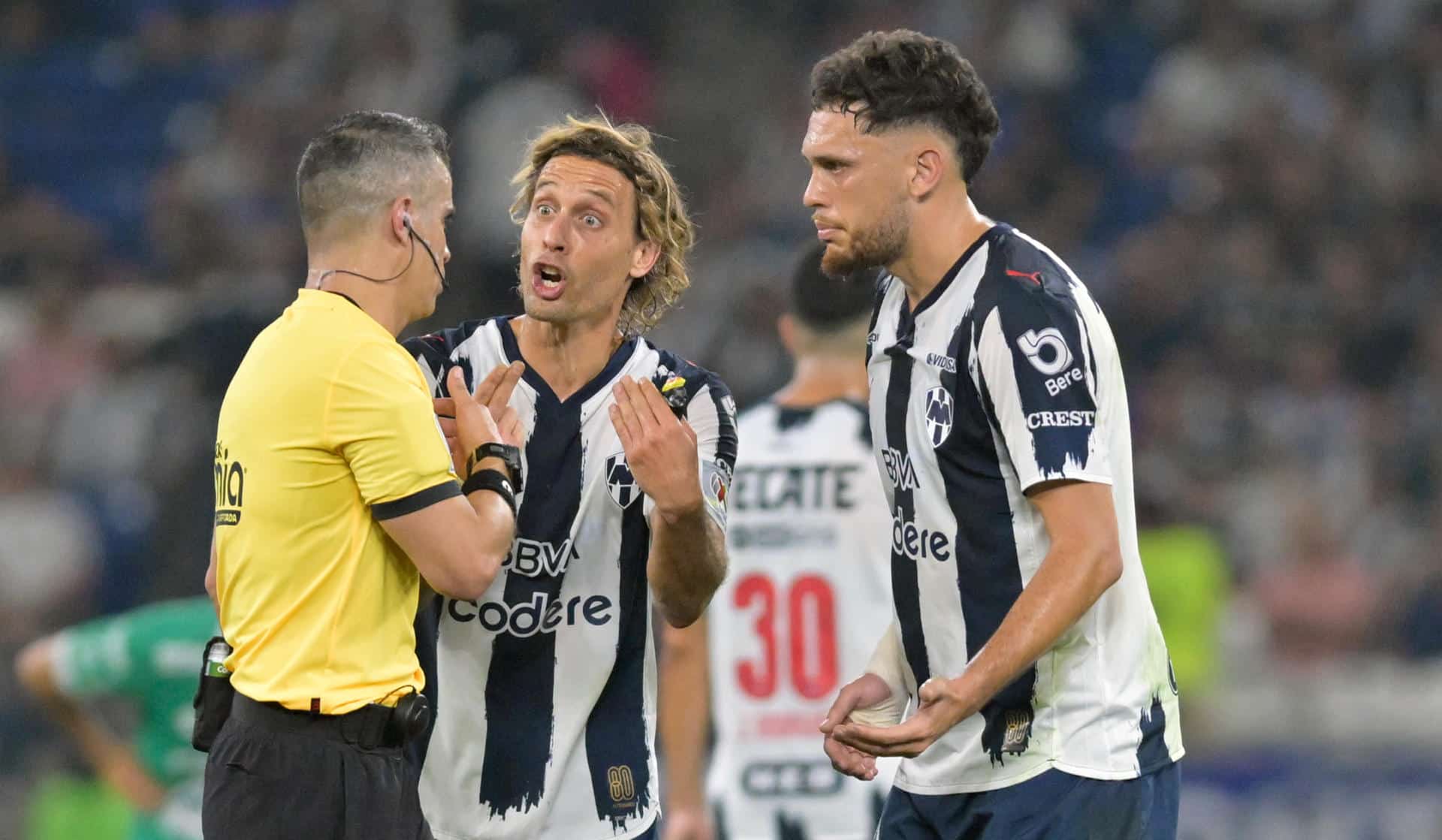 Sergio Canales (c) y Lucas Ocampos (d) de Monterrey reclaman al árbitro Fernando Hernández en un partido ante León en el estadio BBVA en Guadalupe (México). EFE/Miguel Sierra