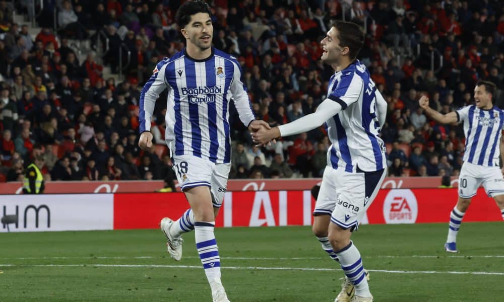 El delantero de la Real Sociedad Carlos Soler (i) celebra su gol, el primero del equipo donostiarra, durante el partido de la jornada 26 de LaLiga entre el RCD Mallorca y la Real Sociedad, este sábado en el estadio de Son Moix, en Palma.- EFE/ Cati Cladera