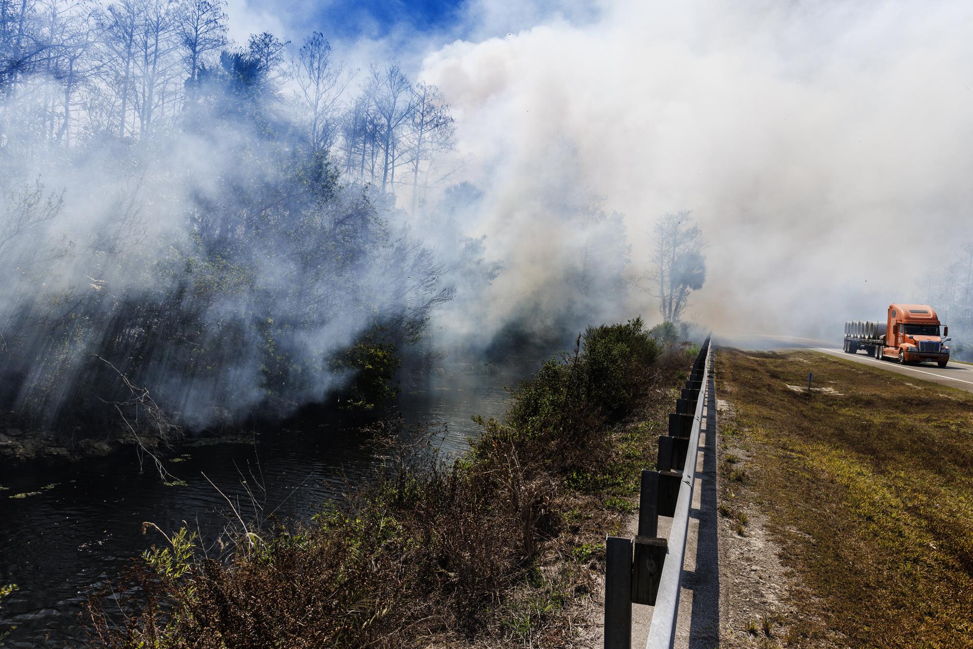 Vehículos circulan mientras arde un incendio forestal en el Parque Nacional Big Cypress, Jerome, Florida, EE. UU., el 24 de febrero de 2026. EFE/CRISTOBAL HERRERA-ULASHKEVICH