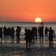Personas observan el atardecer durante un ritual en la Playa Ramírez este lunes, durante la celebración del día de Lemanjá en Montevideo (Uruguay). EFE/ Federico Gutiérrez