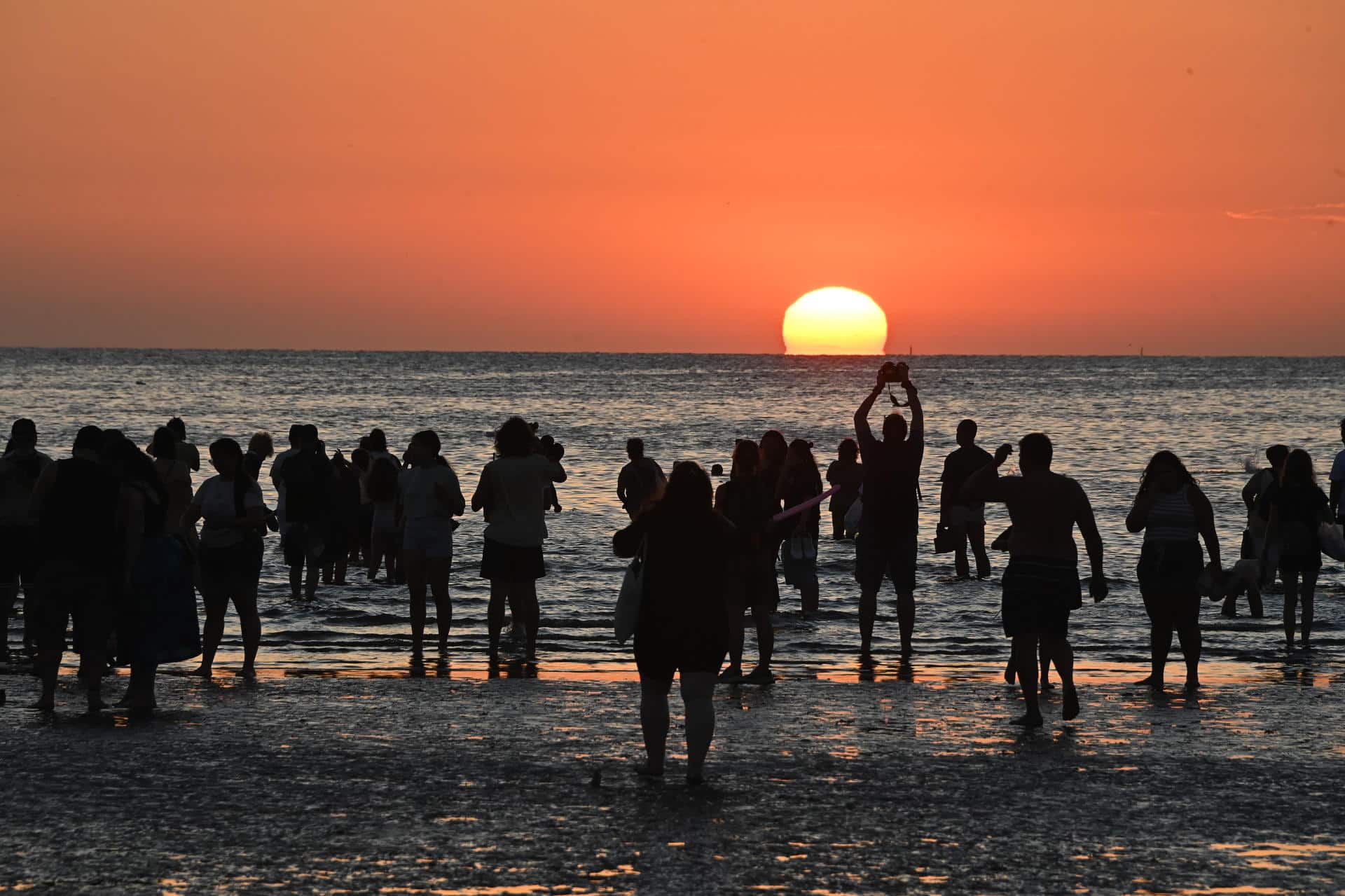 Personas observan el atardecer durante un ritual en la Playa Ramírez este lunes, durante la celebración del día de Lemanjá en Montevideo (Uruguay). EFE/ Federico Gutiérrez