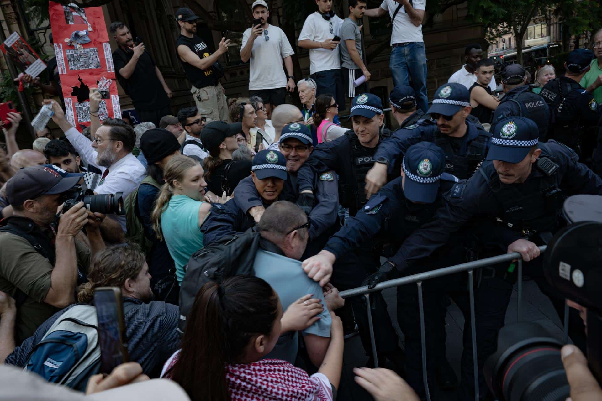 SÍDNEY (Australia), 09/02/2026.- Agentes de policía detienen a manifestantes durante una protesta frente al Ayuntamiento de Sídney contra la visita del presidente israelí, Isaac Herzog, a Australia. EFE/EPA/FLAVIO BRANCALEONE AUSTRALIA AND NEW ZEALAND OUT
