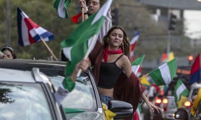 Personas sostienen banderas de diferentes partidos políticos de Costa Rica este domingo, en la fuente de la Hispanidad en San José (Costa Rica). EFE/ Alexander Otárola