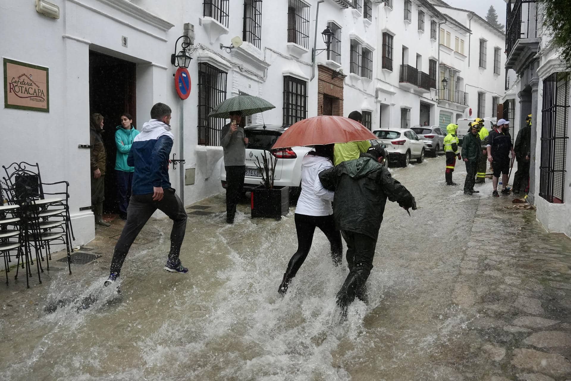 Vecinos de la localidad de Grazalema, en Cádiz (sur de España), corren por una calle inundada, en una imagen de principios de febrero. EFE/Román Ríos