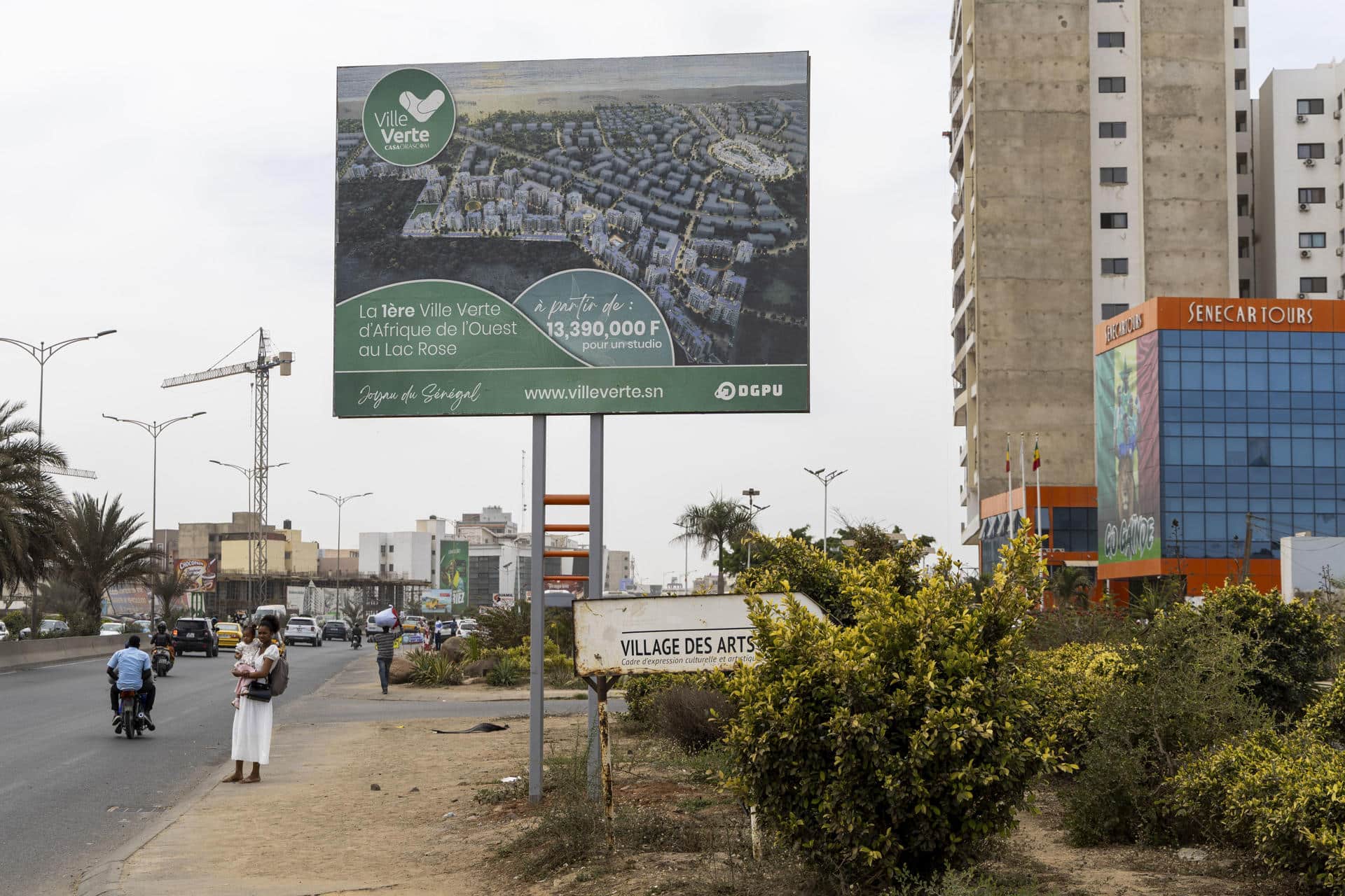 En las dunas coloreadas que bordean el famoso lago Rosa, gran atracción turística de Senegal a apenas 30 minutos de la capital, Dakar, se libra una batalla medioambiental por un proyecto inmobiliario que amenaza a ese paraje natural único. De un lado, el Gobierno senegalés y una multinacional egipcia promueven la construcción de una ciudad verde, moderna y ecológica, que albergaría 18.000 viviendas. En la imagen, vista de un cartel publicitario del proyecto inmobiliario conocido como Ville Verte (ciudad verde, en francés), que amenaza el famoso lago Rosa, gran atracción turística de Senegal a apenas 30 minutos de la capital, visto en Dakar, capital de Senegal. EFE/Eduardo S. Molano.