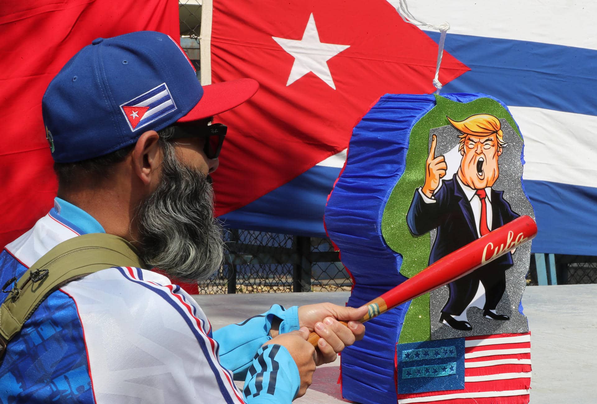 Un hombre golpea una piñata con la imagen de Donald Trump en una manifestación frente a la antigua sede de la Embajada de Estados Unidos este domingo, en Ciudad de México (México). EFE/ Mario Guzmán