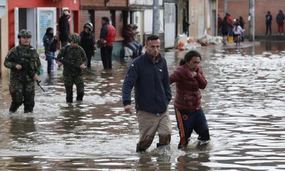 Personas caminan junto a integrantes del Ejército de Colombia en una calle inundada por las fuertes lluvias este jueves, en Facatativá (Colombia). EFE/ Mauricio Dueñas Castañeda