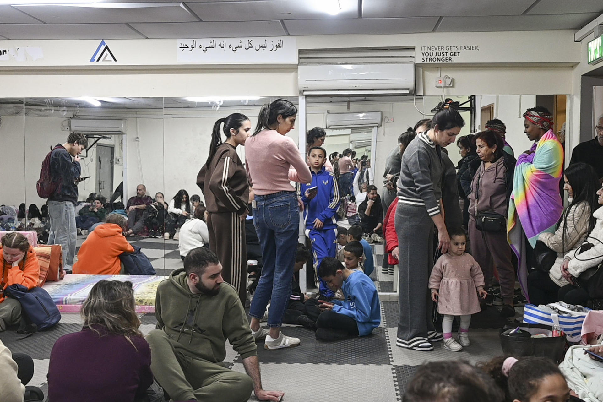 HAIFA (ISRAEL), 04/03/2026.- Varias personas en el único búnker del barrio Wadi Nisnas de Haifa. A pocos metros del único refugio público del que dispone Wadi Nisnas, el barrio de la ciudad de Haifa (norte de Israel) donde viven 9.000 residentes, la mayoría árabes con ciudadanía israelí, los restos de un misil iraní impactaron contra una casa hace dos noches. El episodio no dejó víctimas, pero recordó a sus vecinos lo desprotegidos que están en medio de esta nueva guerra, que ya suma cinco días. EFE/MAGDA GIBELLI