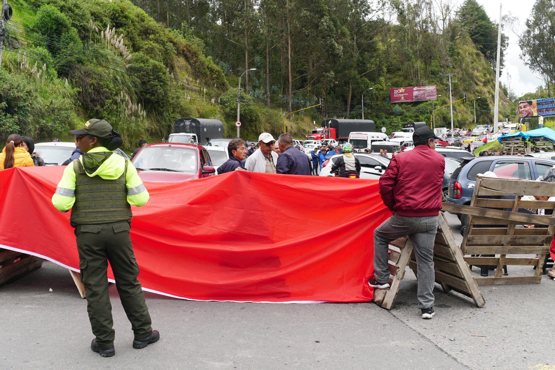 Gremios de comerciantes y transportistas bloquean la carretera que cruza la frontera entre Colombia y Ecuador para protestar contra la guerra comercial que mantienen ambos gobiernos, con una escalada de aranceles que llega a tarifas del 50%, este miércoles en Ipiales (Colombia). EFE / Xavier Montalvo