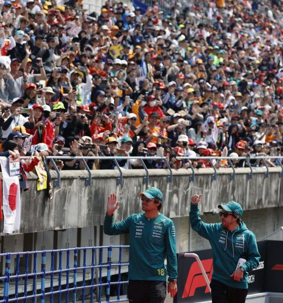 El piloto canadiense de Aston Martin Lance Stroll (izquierda), y el piloto español de Aston Martin Fernando Alonso (derecha), saludan a los aficionados durante el desfile de pilotos previo al Gran Premio de Japón de Fórmula 1 en el circuito de Suzuka International Racing Course. EFE/EPA/FRANCK ROBICHON