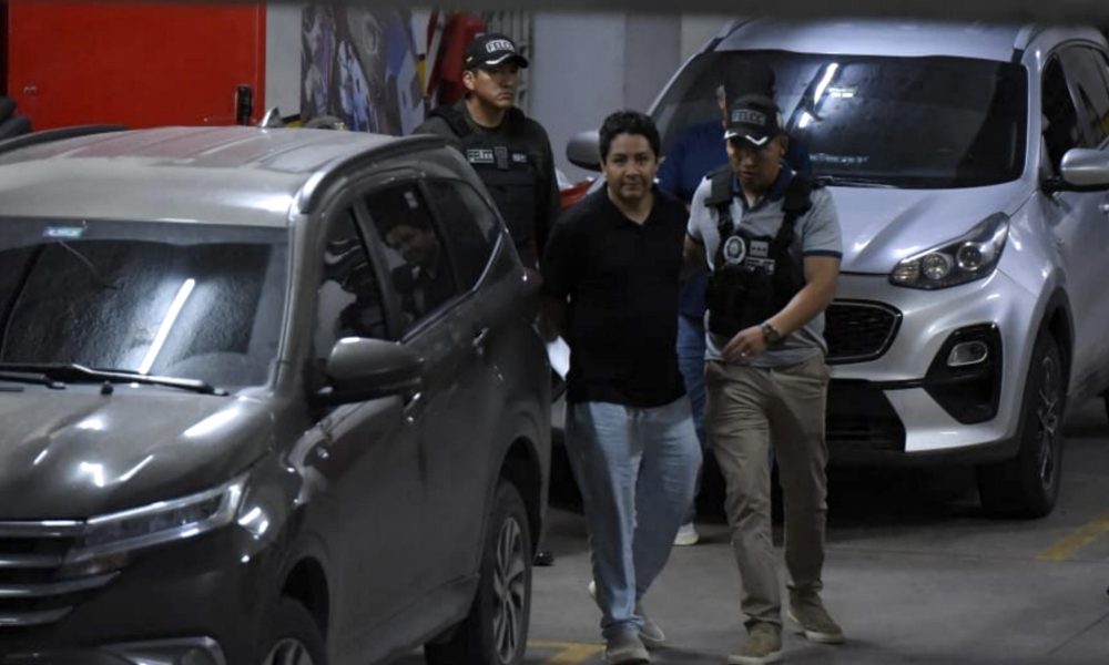 Marcelo Arce Mosqueira (c), hijo mayor del expresidente de Bolivia Luis Arce, es trasladado por agentes de la Policía al Tribunal Departamental de Justicia de Santa Cruz para una audiencia cautelar este viernes, en Santa Cruz (Bolivia). EFE/ STR/