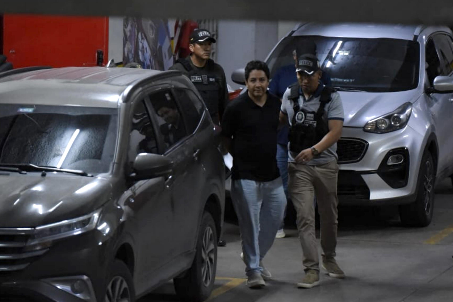 Marcelo Arce Mosqueira (c), hijo mayor del expresidente de Bolivia Luis Arce, es trasladado por agentes de la Policía al Tribunal Departamental de Justicia de Santa Cruz para una audiencia cautelar este viernes, en Santa Cruz (Bolivia). EFE/ STR/