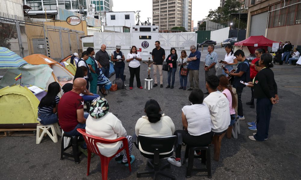 Familiares de presos políticos participan en una eucaristía frente al centro penitenciario de la Policía Nacional Bolivariana (PNB) conocido como zona 7 este viernes, en Caracas (Venezuela). EFE/ Ronald Pena R