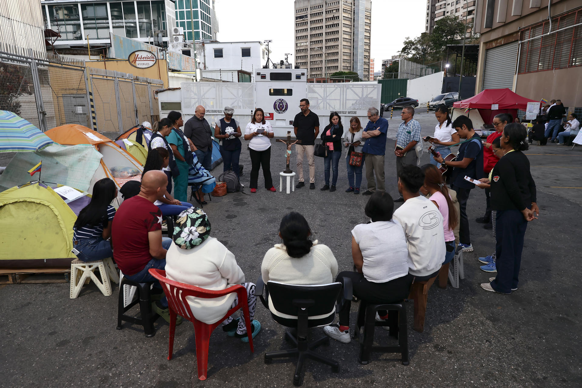 Familiares de presos políticos participan en una eucaristía frente al centro penitenciario de la Policía Nacional Bolivariana (PNB) conocido como zona 7 este viernes, en Caracas (Venezuela). EFE/ Ronald Pena R