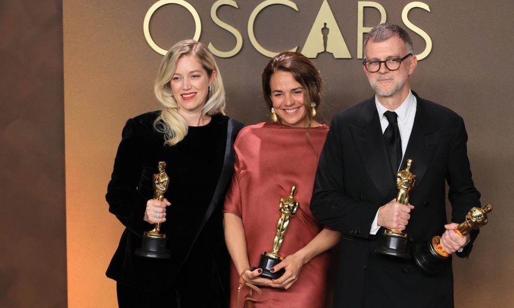 Sara Murphy (i) Paul Thomas Anderson (d) posan con la estatuilla a mejor película por 'One Battle After Another' junto a Carmen Ruiz de Huidobro este 15 de marzo de 2026, en la ceremonia 98º de los premios Óscar, en Los Ángeles (Estados Unidos). EFE/ Armando Arorizo