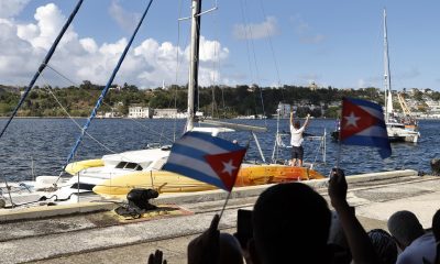 Personas observan la llegada de veleros este sábado, en La Habana (Cuba). EFE/ Ernesto Mastrascusa