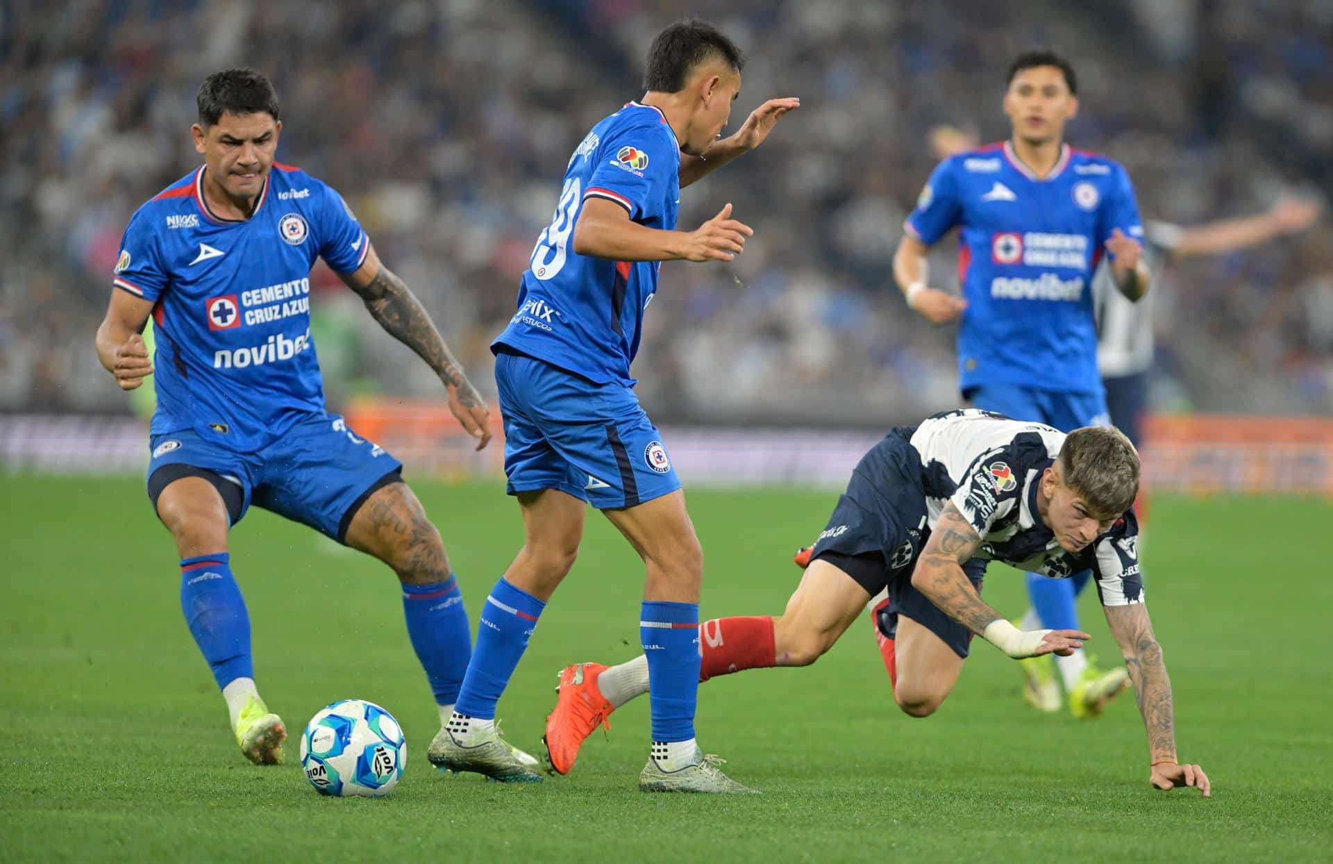 Luca Orellano (d) de Monterrey disputa el balón con Carlos Rodriguez (c) y Gabriel Fernandez de Cruz Azul el pasado sábado, en un partido de la Liga MX entre Monterrey y Cruz Azul, en el estadio BBVA en Guadalupe (México). EFE/Miguel Sierra