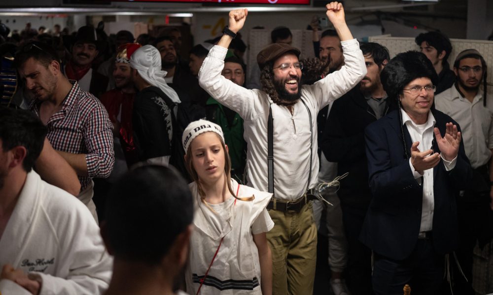 Refugiados de los misiles en el aparcamiento de un centro comercial de Tel Aviv, los israelíes celebran este lunes noche la fiesta de Purim, el carnaval judío, que conmemora precisamente la salvación del pueblo judío de los persas hace 2.500 años. EFE/ Magda Gibelli