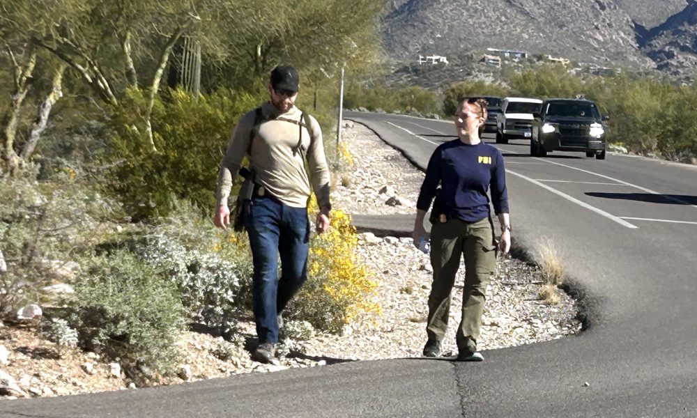 Dos agentes del FBI investigan en la zona que rodea la casa de Nancy Guthrie en Catalina Foothills, (Az, EE.UU.). Imagen de archivo. EFE/ María León