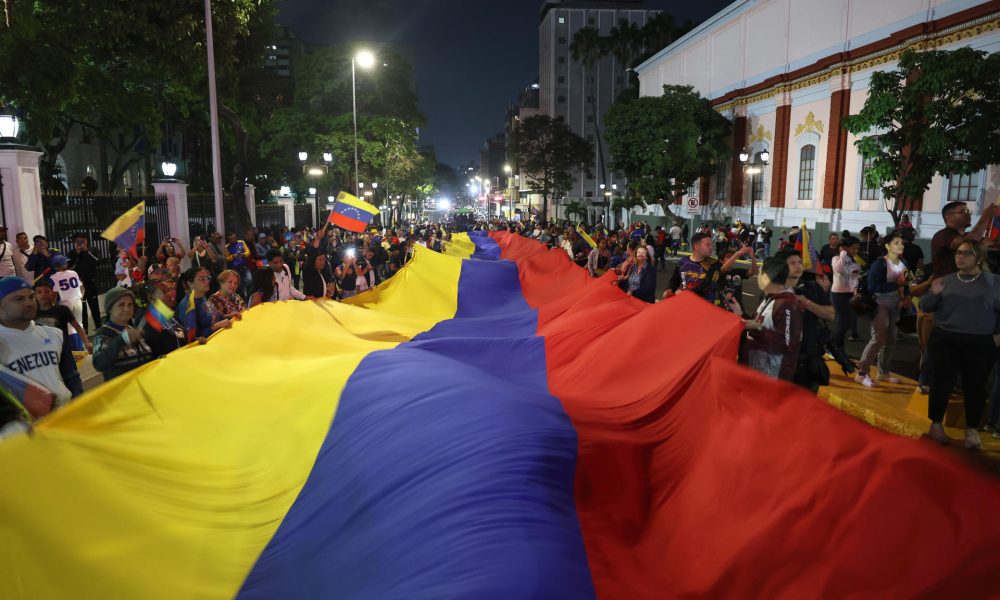 Decenas de personas sostienen una bandera de Venezuela este miércoles durante las celebraciones en las calles de Caracas por la conquista del Clásico Mundial de Béisbol. EFE/ Miguel Gutiérrez