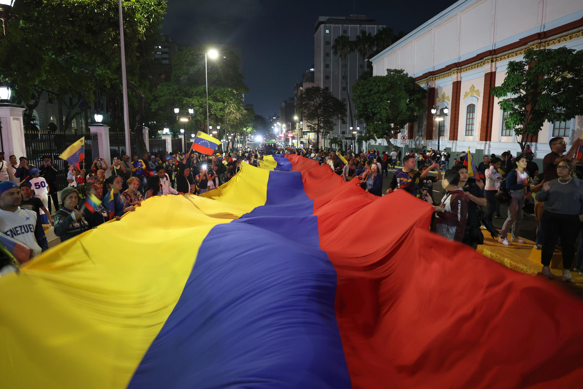 Decenas de personas sostienen una bandera de Venezuela este miércoles durante las celebraciones en las calles de Caracas por la conquista del Clásico Mundial de Béisbol. EFE/ Miguel Gutiérrez