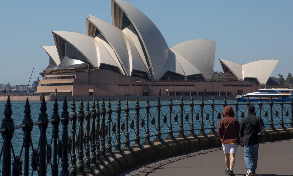 Fotografía de archivo de un par de personas caminando cerca del edificio de la Ópera, en Sídney. 
EFE/EPA/BRENT LEWIN AUSTRALIA AND NEW ZEALAND OUT