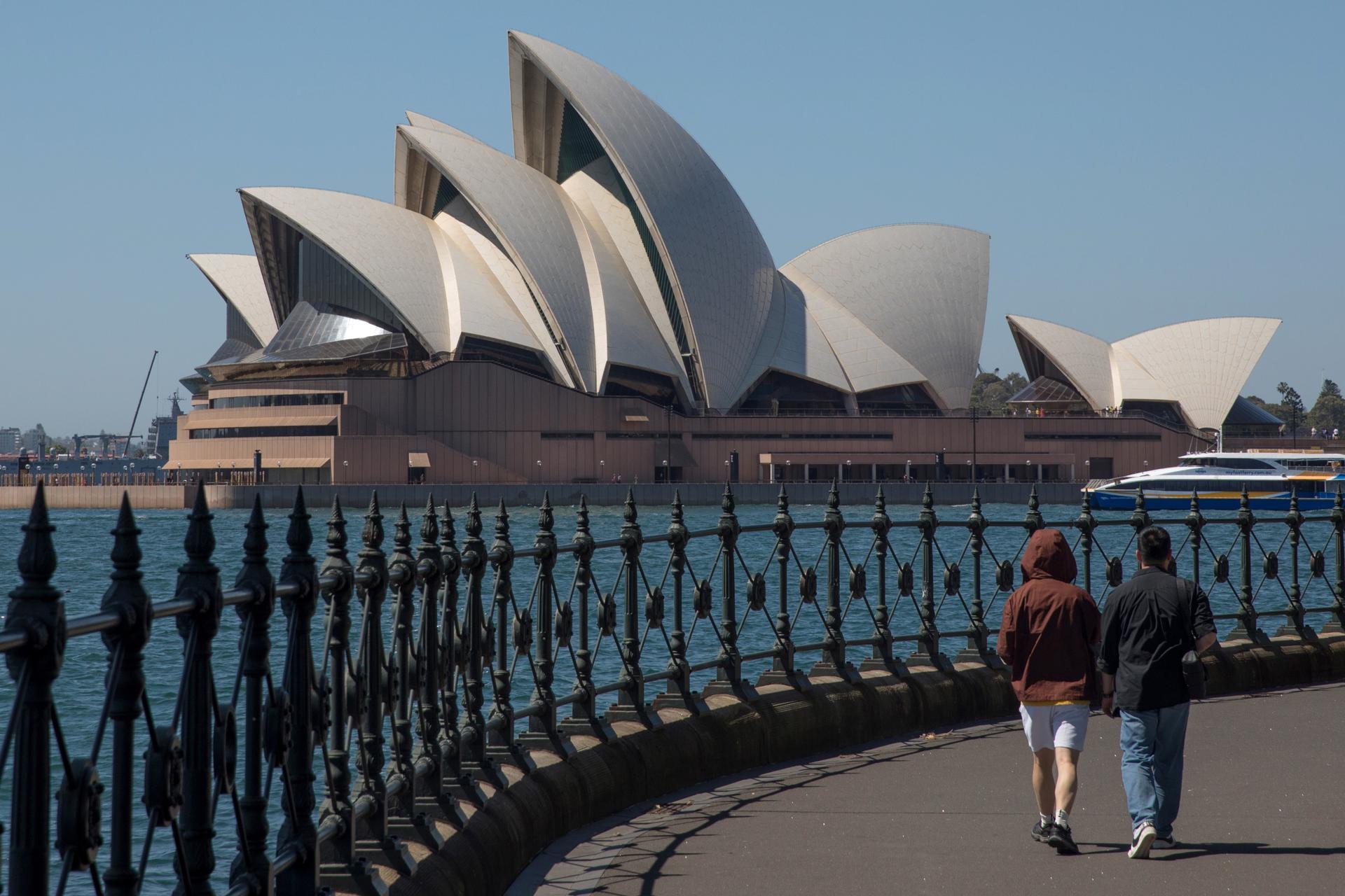 Fotografía de archivo de un par de personas caminando cerca del edificio de la Ópera, en Sídney. 
EFE/EPA/BRENT LEWIN AUSTRALIA AND NEW ZEALAND OUT