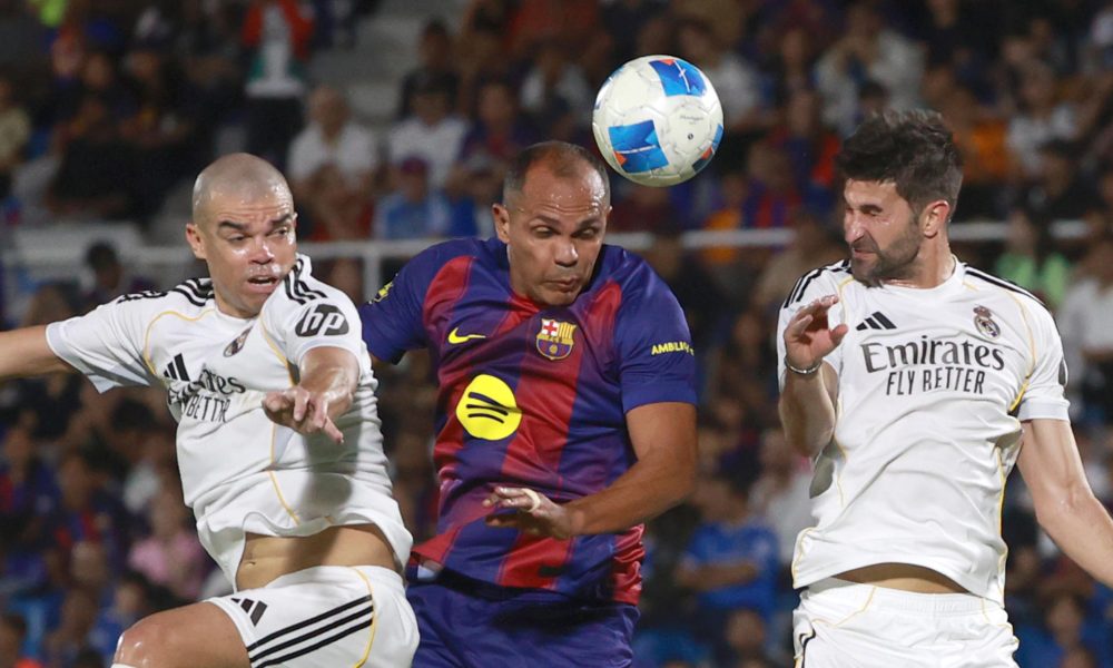 Giovanni Silva (c), del equipo de las leyendas del Barcelona disputa un balón con Pepe (i), de las leyendas de Real Madrid, en el estadio Olímpico Félix Sánchez en Santo Domingo (República Dominicana). EFE/Orlando Barría