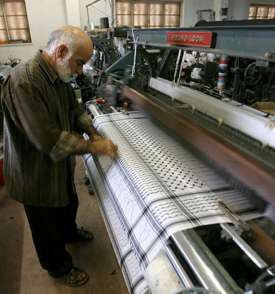 Una persona trabaja junto a un telar en una fábrica textil. Imagen de archivo. EFE/Abed Al Hashlamoun