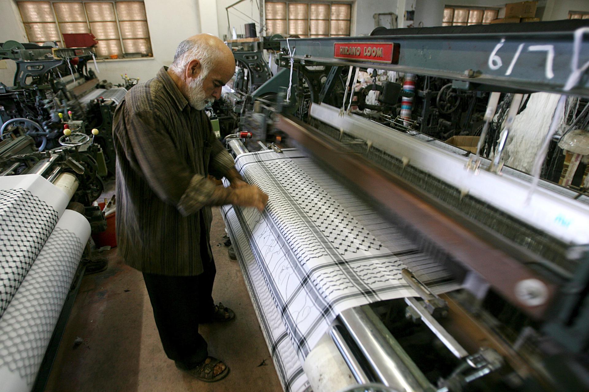 Una persona trabaja junto a un telar en una fábrica textil. Imagen de archivo. EFE/Abed Al Hashlamoun