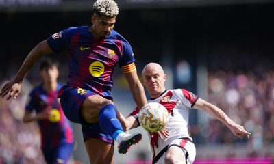 El jugador del FC Barcelona Ronald Araujo (i) lucha por el balón con Isi (d), del Rayo Vallecano, durante su partido de la jornada 29 de LaLiga EA Sports en el Camp Nou, este domingo. EFE/ Alejandro Garcia