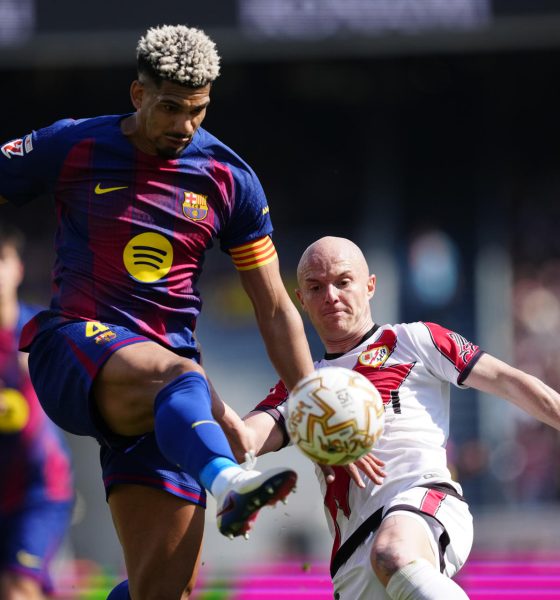 El jugador del FC Barcelona Ronald Araujo (i) lucha por el balón con Isi (d), del Rayo Vallecano, durante su partido de la jornada 29 de LaLiga EA Sports en el Camp Nou, este domingo. EFE/ Alejandro Garcia