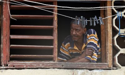 Un hombre observa desde una ventana durante un apagón en La Habana (Cuba). EFE/ Ernesto Mastrascusa