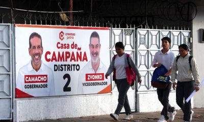 Personas camina cerca a una valla propagandística del candidato a la gobernación de Santa Cruz, Luis Fernando Camacho, en Santa Cruz (Bolivia). EFE/ Luis Gandarillas