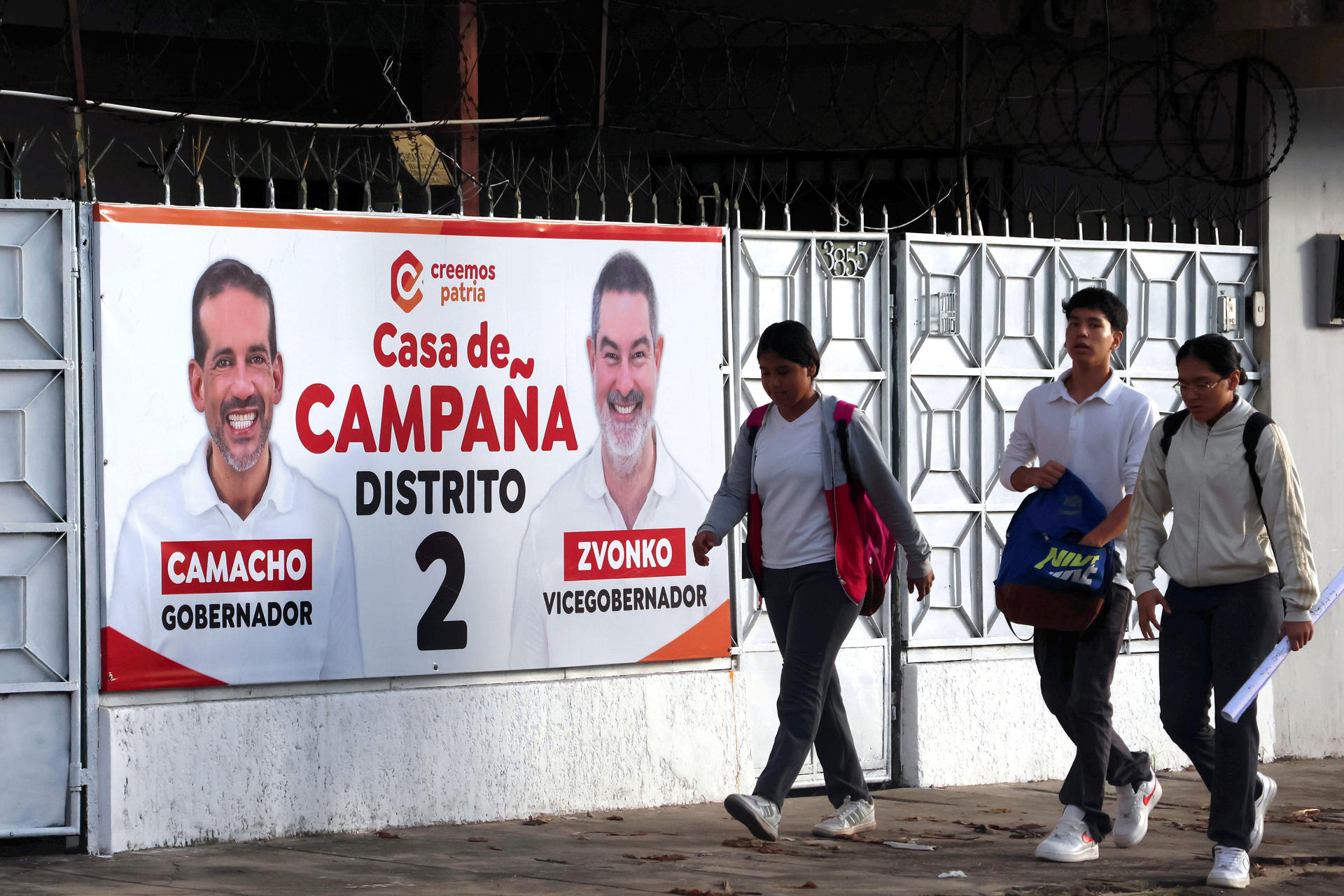 Personas camina cerca a una valla propagandística del candidato a la gobernación de Santa Cruz, Luis Fernando Camacho, en Santa Cruz (Bolivia). EFE/ Luis Gandarillas