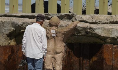 Una persona observa una escultura de barro este sábado, en el muro fronterizo en Tijuana (México). EFE/ Joebeth Terríquez