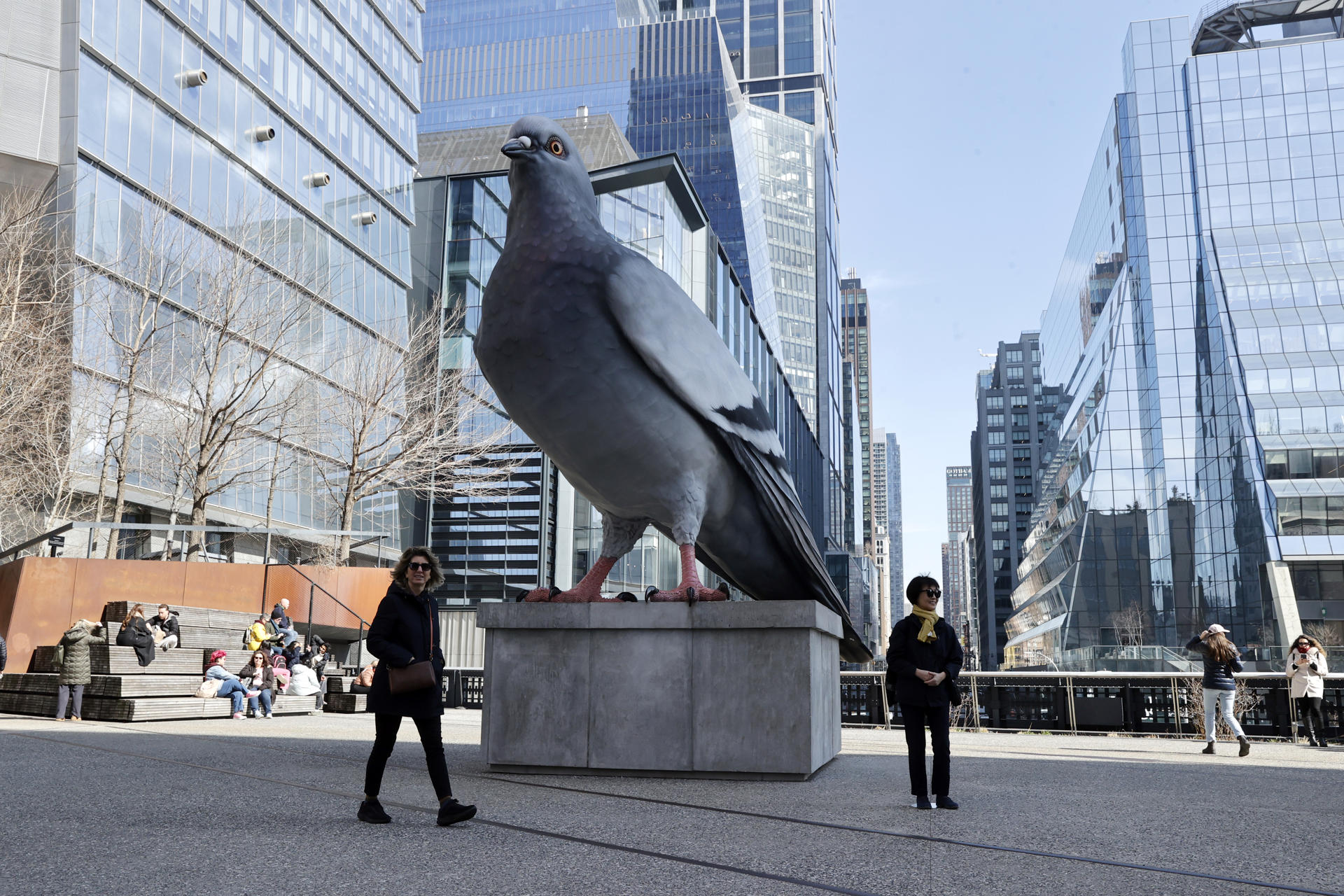 Personas caminan cerca de la escultura hiperrealista 'Dinosaur', una paloma de seis metros de altura de aluminio fundido pintada a mano por el artista colombiano Iván Argote este viernes, en el High Line de Manhattan en Nueva York (EE.UU.). EFE/ Sarah Yáñez-richards