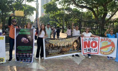 Personas sostiene carteles durante una protesta en contra de una reciente sentencia de la Corte Constitucional que permite que adolescentes puedan cambiar su género en el documento de identidad si cumplen con determinados requisitos, este miércoles en Guayaquil (Ecuador). EFE/ Cristina Bazan