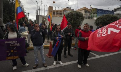 Personas sostienen banderas durante una manifestación frente a la Embajada de Cuba en Ecuador este jueves, en Quito (Ecuador). EFE/ José Jácome
