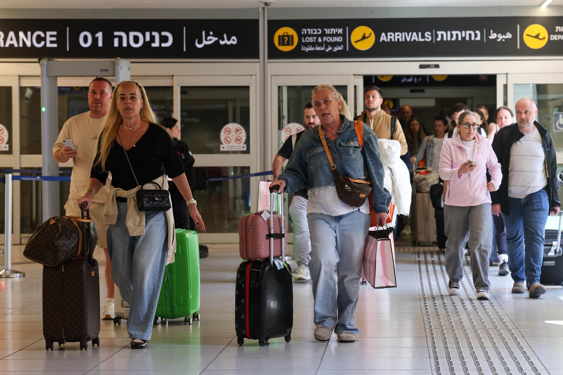 Pasajeros con su equipaje reaccionan al salir de la terminal de llegadas en el Aeropuerto Internacional Ben Gurion, cerca de Tel Aviv, Israel, 05 de marzo de 2026. La Autoridad de Aviación Civil de Israel ha comenzado una reapertura por fases del espacio aéreo civil, operando vuelos especiales de repatriación para unos 100.000 ciudadanos israelíes varados en el extranjero desde que comenzó el cierre de cinco días el 28 de febrero. Los primeros vuelos de entrada llegaron de Atenas y Roma en medio de las tensiones regionales en curso tras los ataques conjuntos de EE.UU.-Israel y la retaliación de Irán. (Atenas, Roma) EFE/EPA/ABIR SULTAN